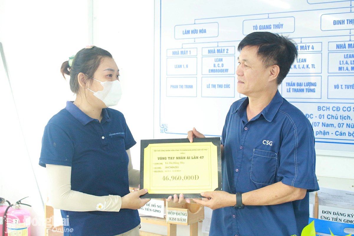 Ông Đặng Tuấn Tú, Chủ tịch Công đoàn cơ sở Công ty TNHH Changshin Việt Nam trao hỗ trợ cho chị Võ Thị Ngọc Thu để có thêm chi phí chữa bệnh. Ảnh: Nguyễn Hòa