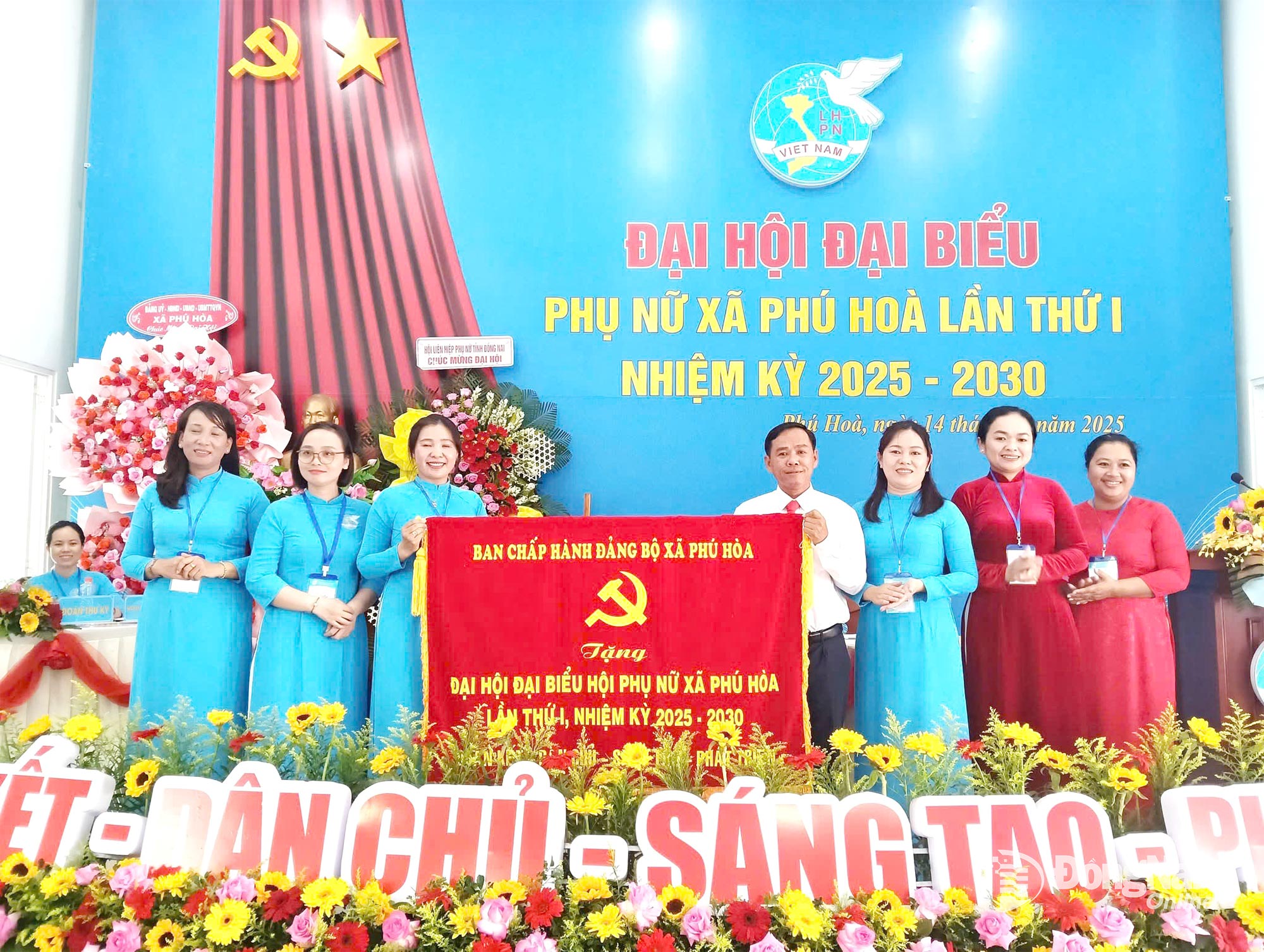 Dinh Kim Tuan, Permanent Deputy Secretary of the Phu Hoa Commune Party Committee, presents flowers and a banner from the Party Committee, People’s Council, People’s Committee, and Vietnam Fatherland Front Committee of the commune to congratulate the congress. Photo courtesy of Contributor