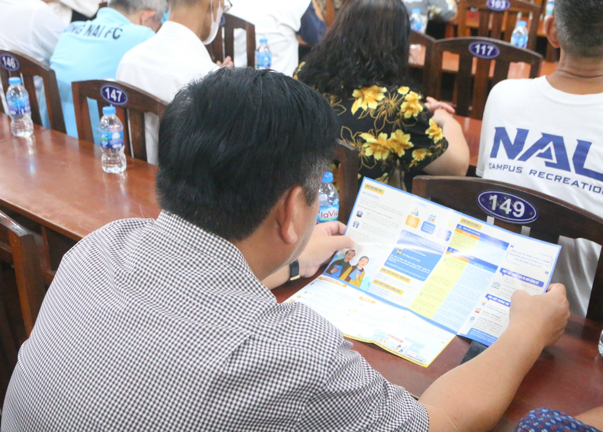 Người dân tìm hiểu thông tin về lợi ích khi tham gia bảo hiểm xã hội, bảo hiểm y tế tại Hội nghị phát triển đối tượng tham gia bảo hiểm do Bảo hiểm xã hội tỉnh Đồng Nai tổ chức tại phường Trấn Biên. Ảnh: Hạnh Dung