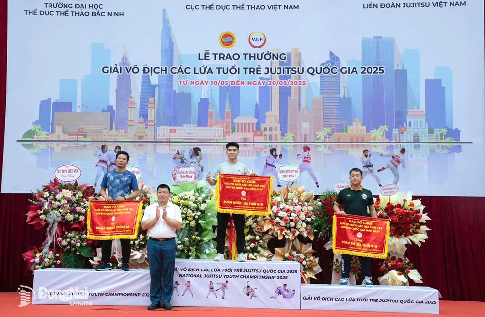 The Dong Nai delegation on the podium receiving the flag for overall first place in the U-18 age group.

