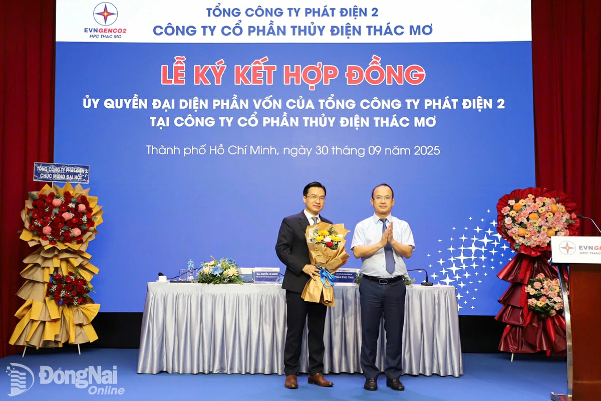 Ông Nguyễn Hữu Thịnh, Thành viên Hội đồng quản trị kiêm Tổng giám đốc EVNGENCO2 (bên phải) tặng hoa chúc mừng ông Nguyễn Lê Hoàng. Ảnh Ngọc Bích
