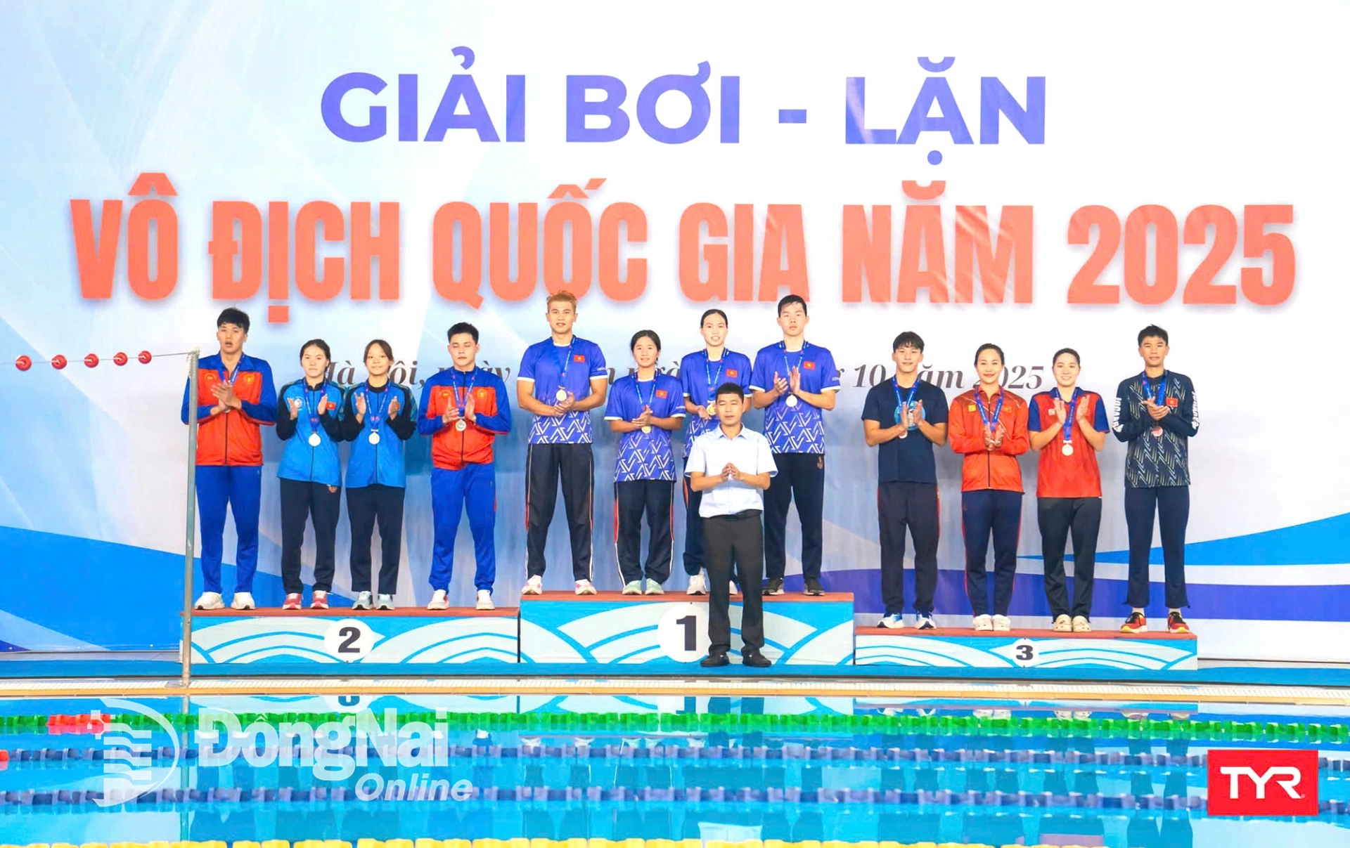 Vận động viên Vũ Đặng Nhật Nam (trên bục, thứ 5 từ trái qua) cùng các đồng đội nhận huy chương vàng nội dung tiếp sức MIX 4x100m chân vịt đôi - vòi hơi chân vịt. Ảnh: ĐVCC