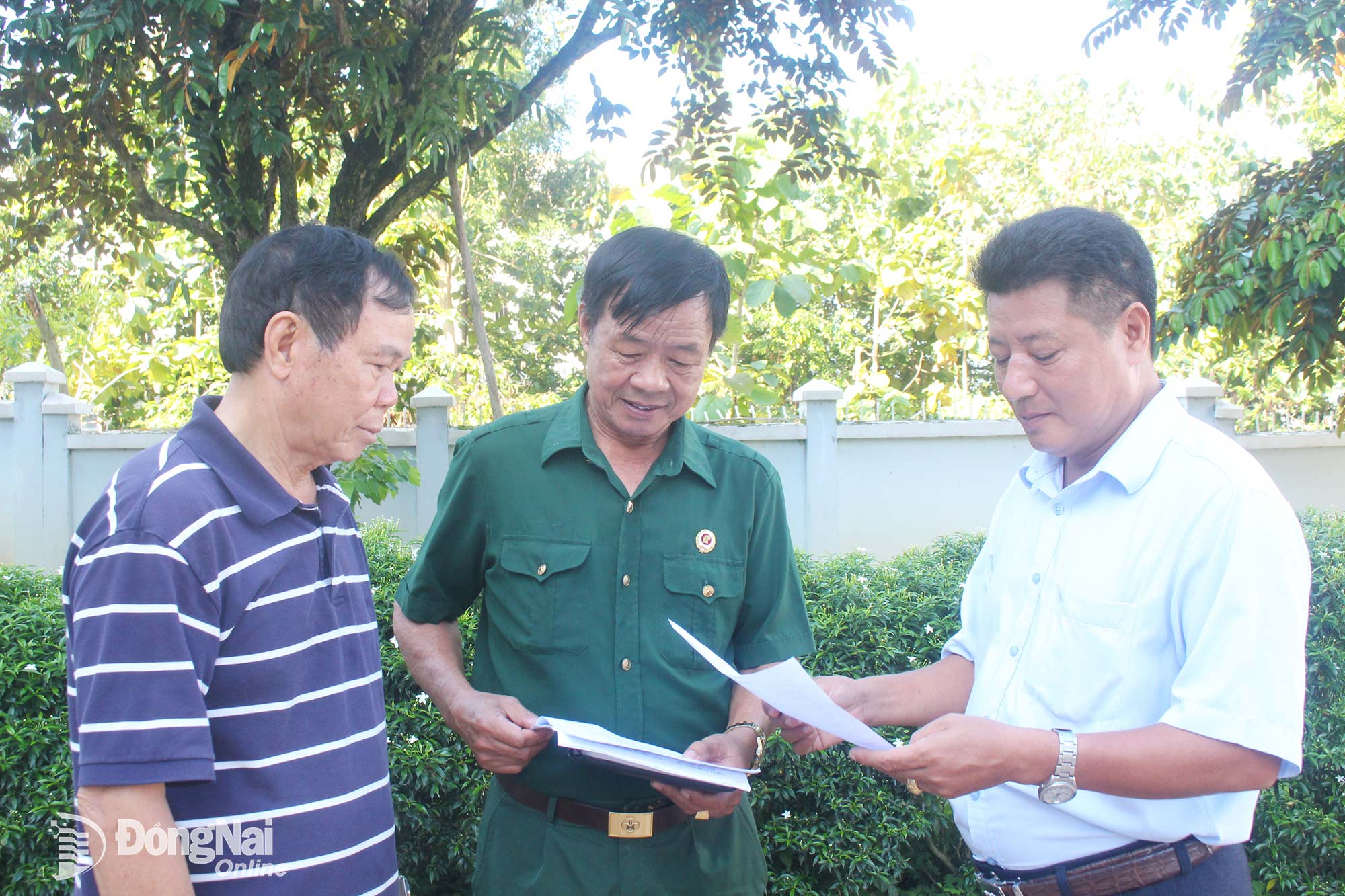 Leaders of the Tri An Ward Veterans Association talk with Nguyen Manh Hung (far left) about the association’s activities.