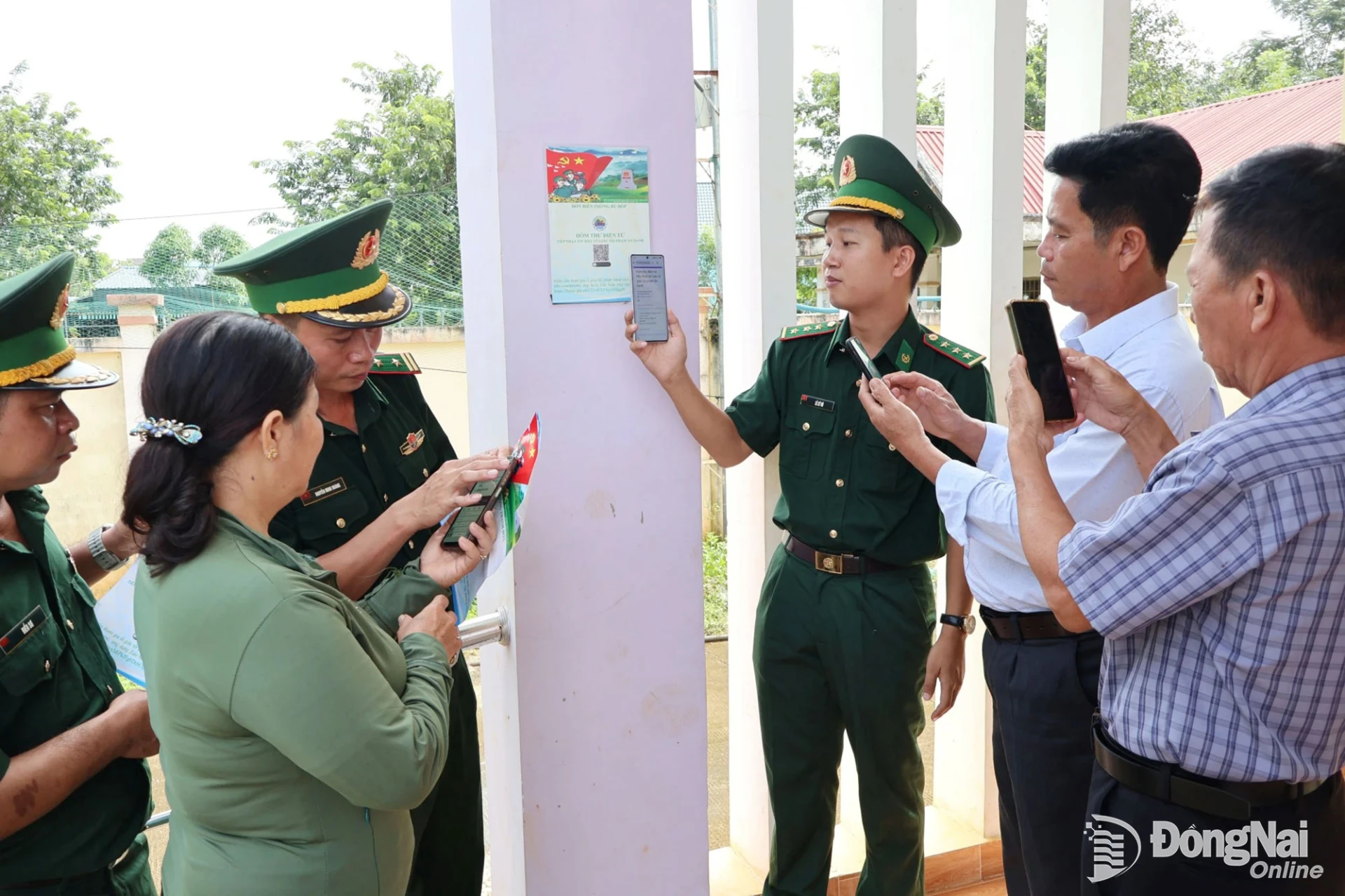 Cán bộ, chiến sĩ Đồn biên phòng Thanh Hòa hướng dẫn người dân thôn Đoàn Kết, xã Thiện Hưng cài đặt hòm thư điện tử tố giác tội phạm. Ảnh: Nguyệt Hà
