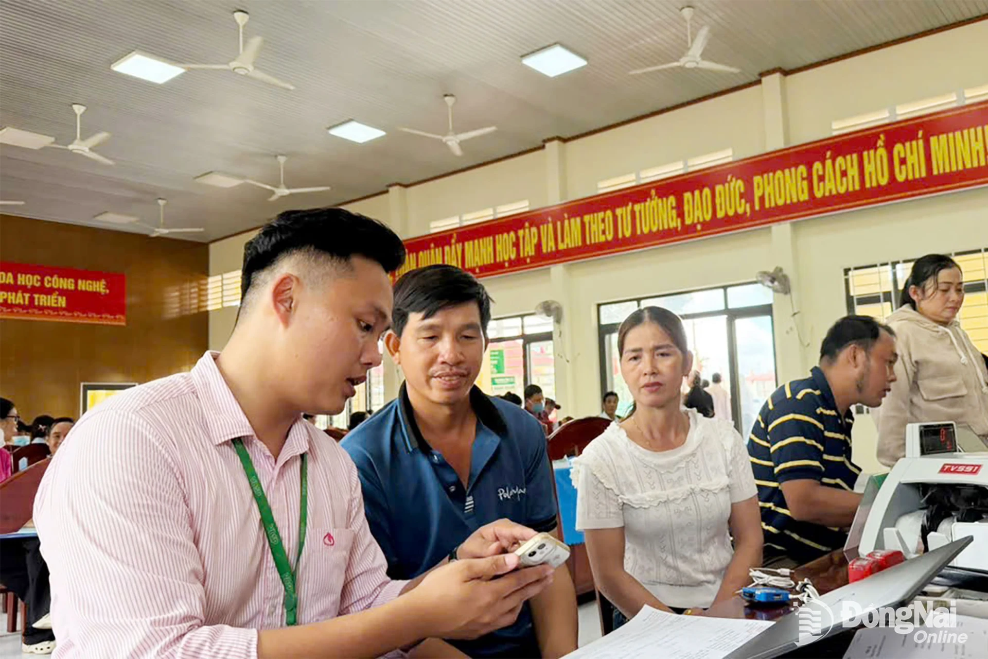 Các hộ dân tại Điểm giao dịch Xuân Đông được hướng dẫn sử dụng app VBSP SMARTBANKING sau khi tiếp nhận vốn vay học sinh - sinh viên. Ảnh: Duy Tân


