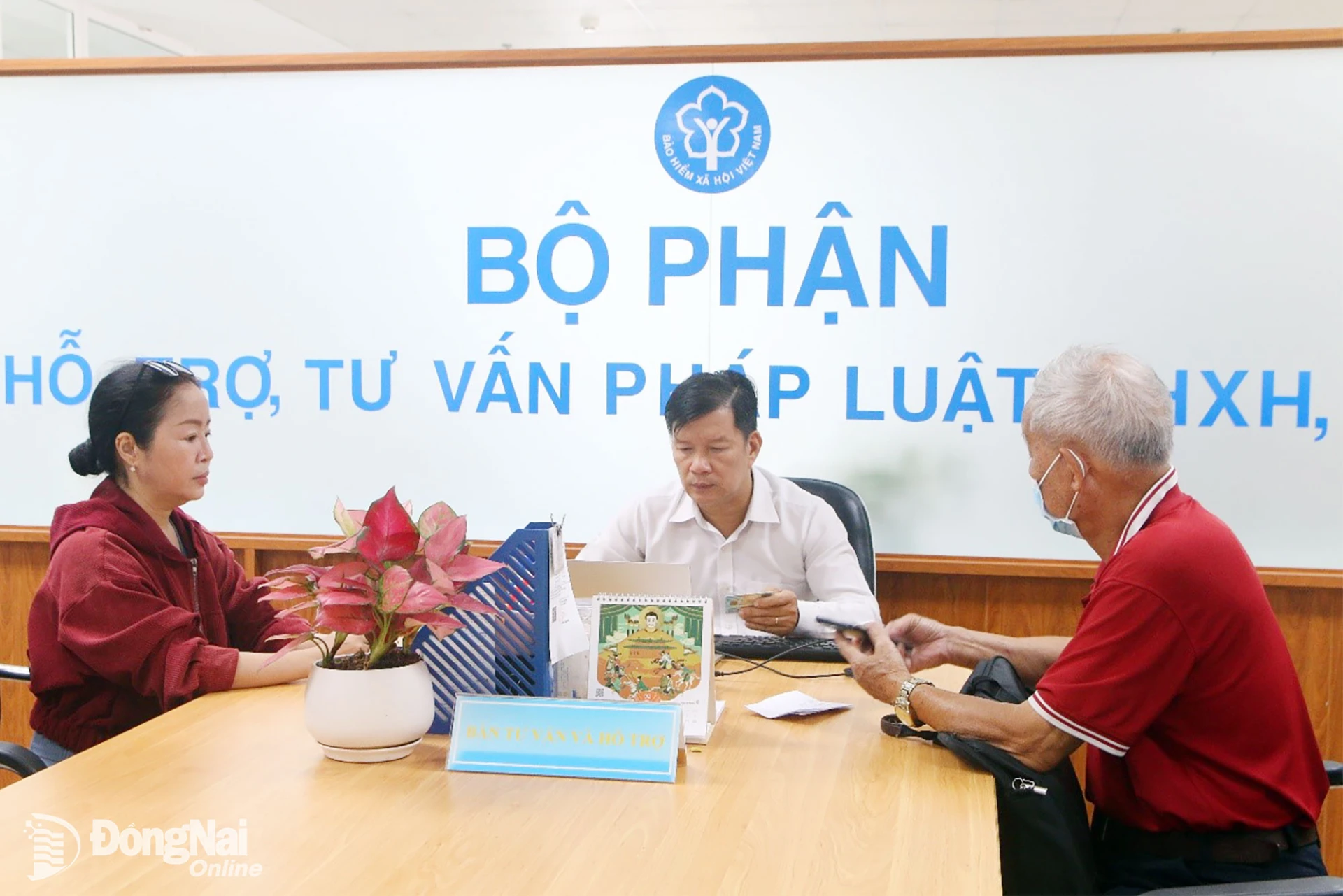 Cán bộ BHXH Đồng Nai hỗ trợ người dân cập nhật thông tin cá nhân trên ứng dụng VNeID. Ảnh: Hạnh Dung

