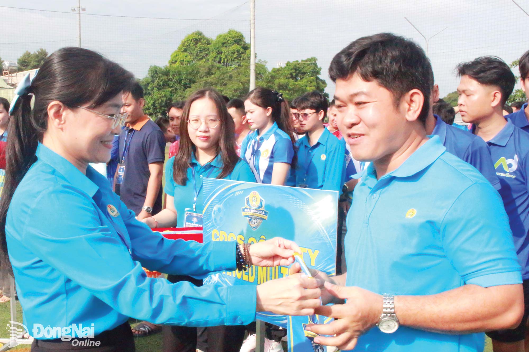 Bui Thi Bich Thuy, Vice President of the Dong Nai City Labor Federation, presents commemorative banners to teams participating in the 2026 Workers, Public Employees, and Laborers Football Tournament. Photo: Nguyen Hoa


