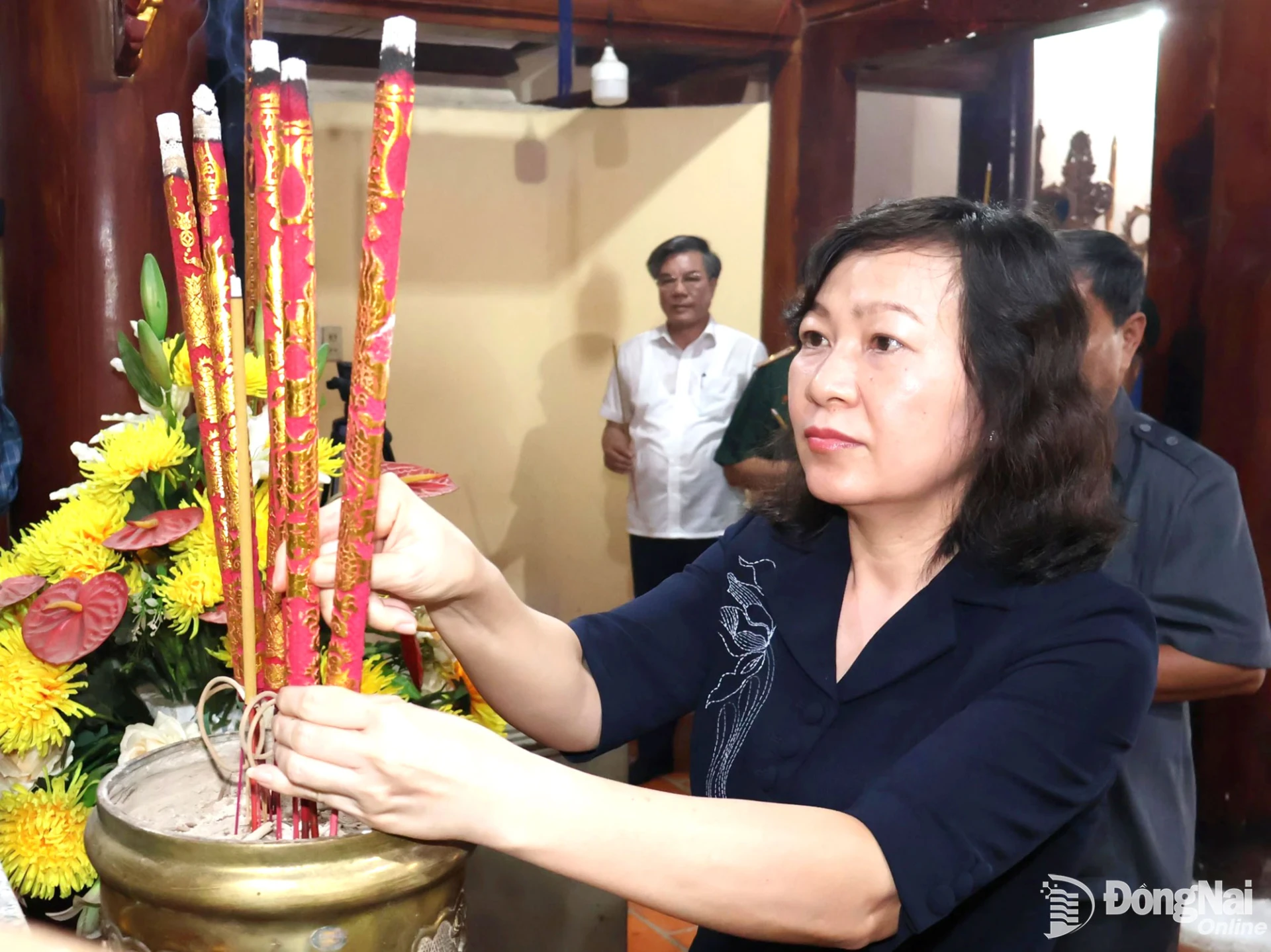 Huynh Thi Hang, Deputy Secretary of the City Party Committee and Chairwoman of the citys Vietnam Fatherland Front Committee, offers incense in tribute to fallen soldiers at the Bang Lang Hill historical site. Photo: Nguyet Ha

