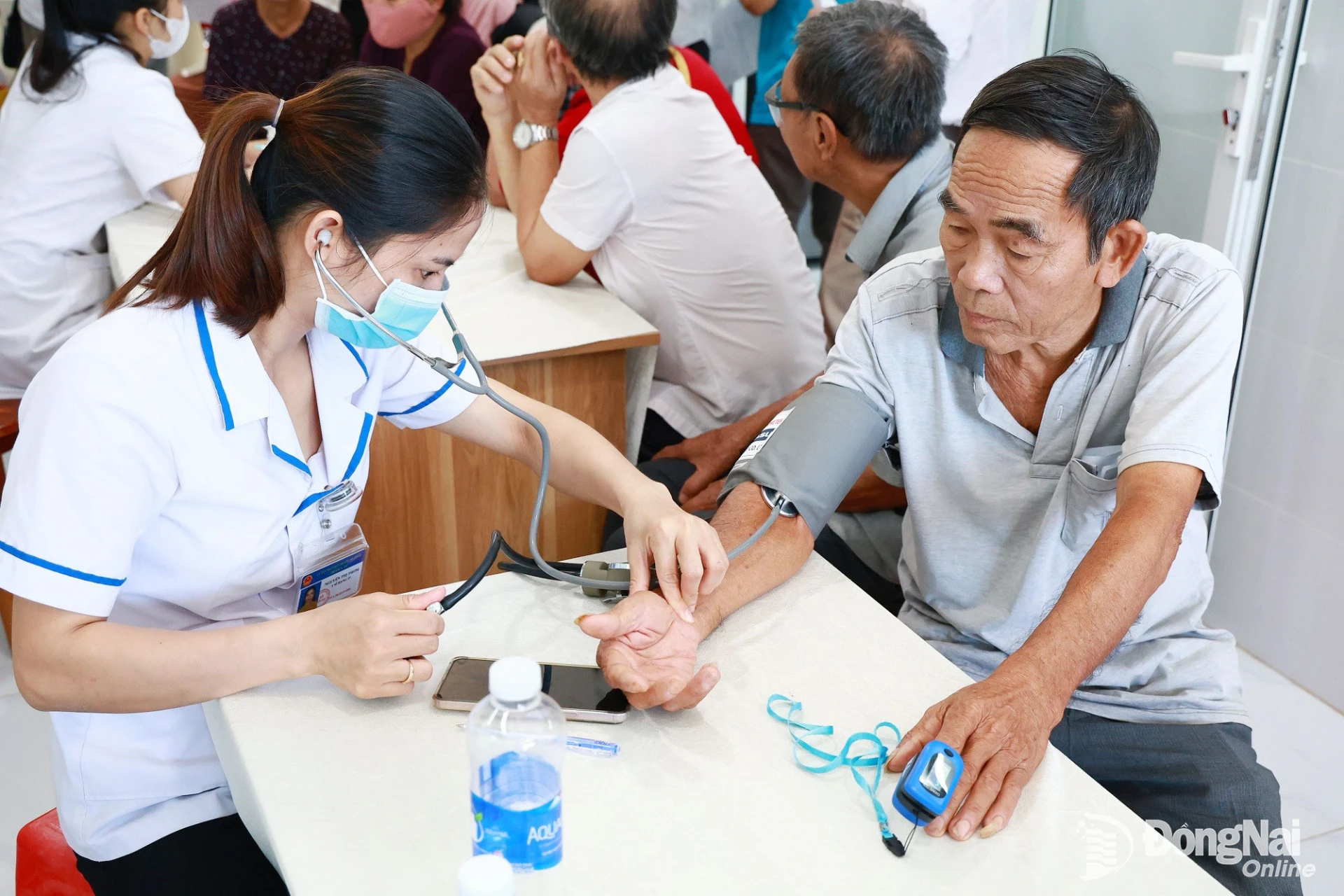 Nhân viên y tế đo huyết áp cho người cao tuổi. Ảnh: Hà Phú Đại