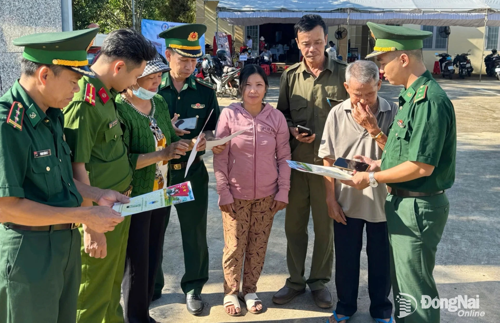 Trung úy Trần Thế Anh (bìa phải) hướng dẫn người dân xã Hưng Phước cài đặt mã quét QR Hòm thư điện tử tố giác tội phạm khu vực biên giới. Ảnh: ĐVCC
