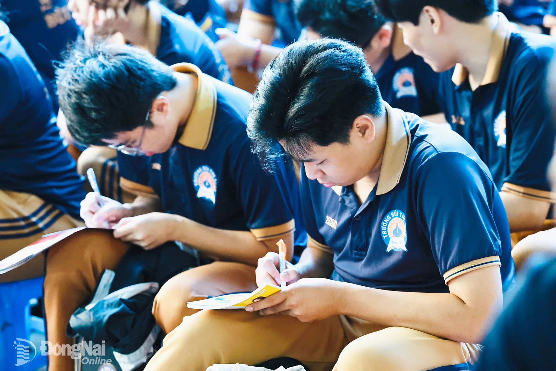 Các em học sinh ghi chép nội dung hướng nghiệp để nghiên cứu lựa chọn nghề nghiệp cho bản thân. Ảnh: Công Nghĩa