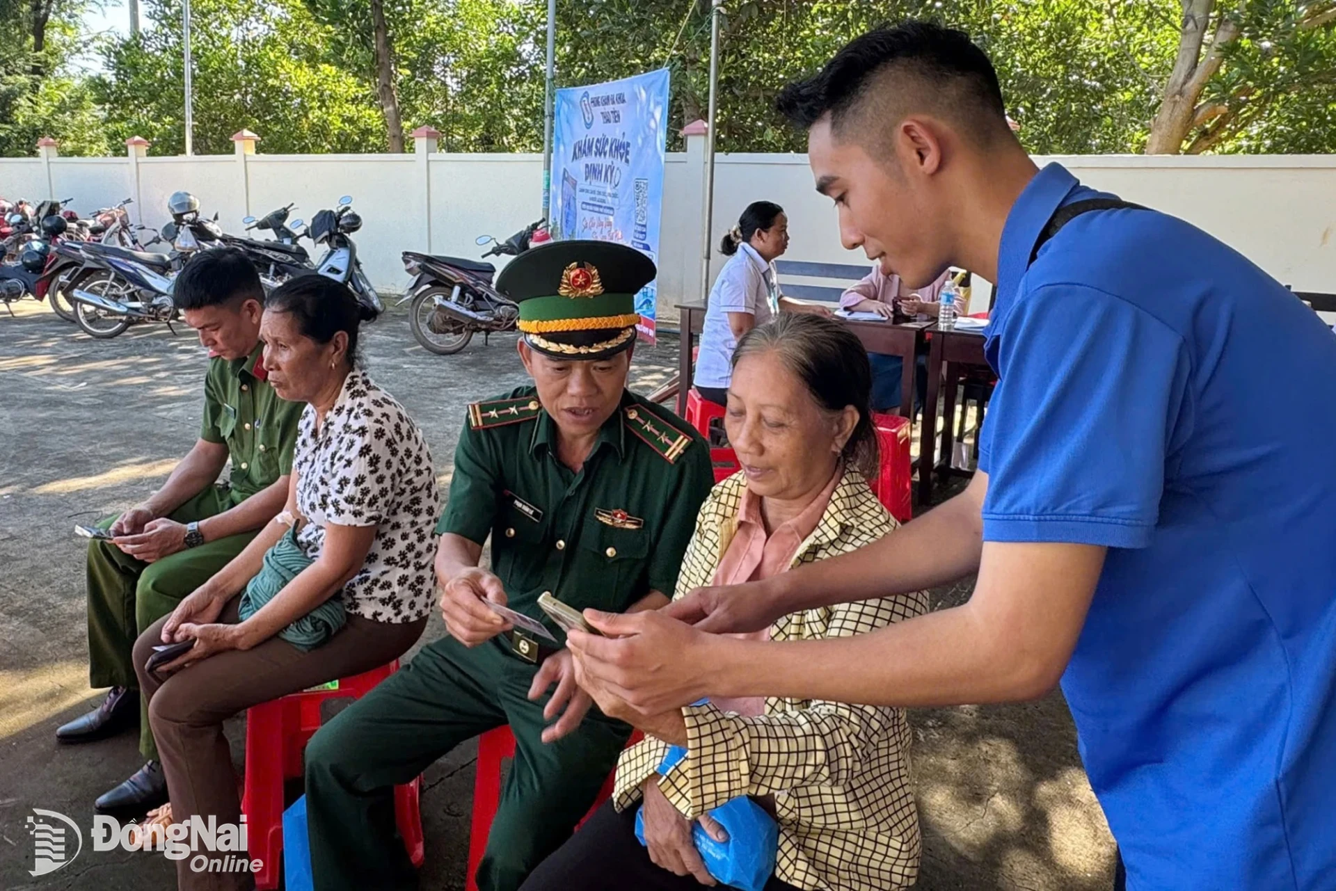 Cán bộ, chiến sĩ Đồn biên phòng Phước Thiện phối hợp các lực lượng hỗ trợ người dân xã Hưng Phước cài đặt mã quét QR Hòm thư điện tử tố giác tội phạm. Ảnh: ĐVCC
