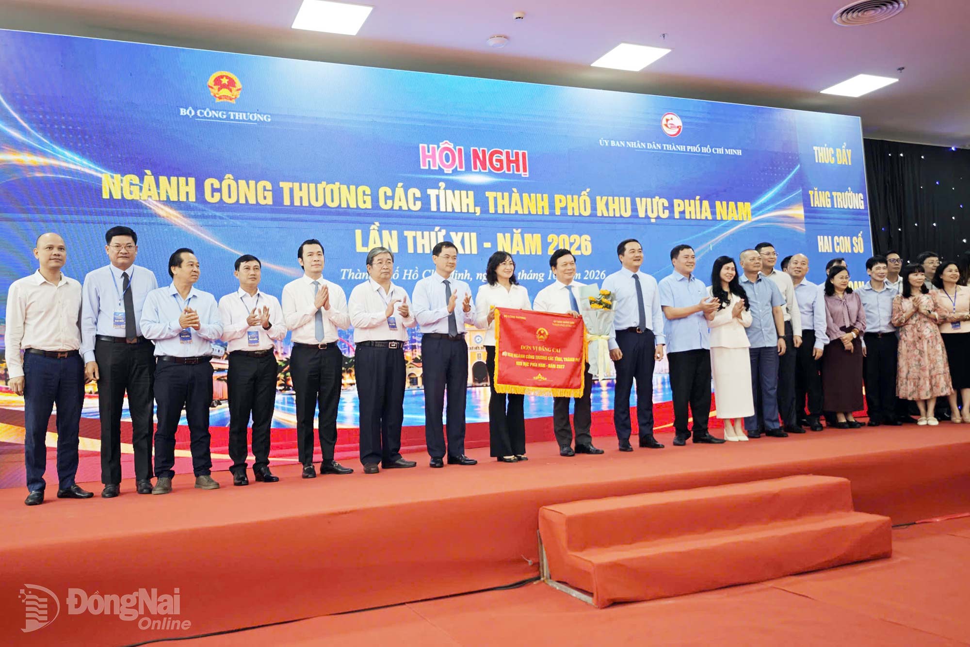 Ministry of Industry and Trade leader hands over the host flag for the 2027 industry and trade conference of southern provinces and cities to Dong Nai City. Photo: Hai Quan

