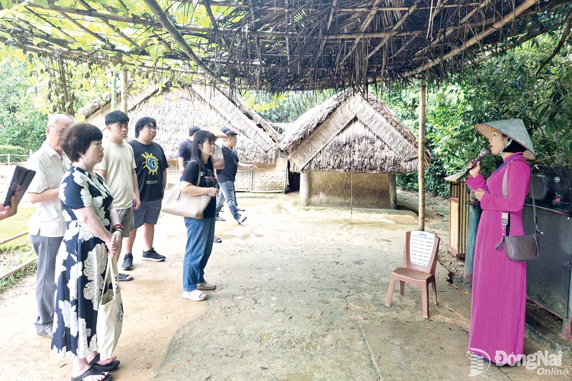 Du khách nghe thuyết minh về nhà ông ngoại Bác Hồ và nhà của gia đình Bác Hồ ở làng Hoàng Trù, xã Kim Liên, tỉnh Nghệ An.

