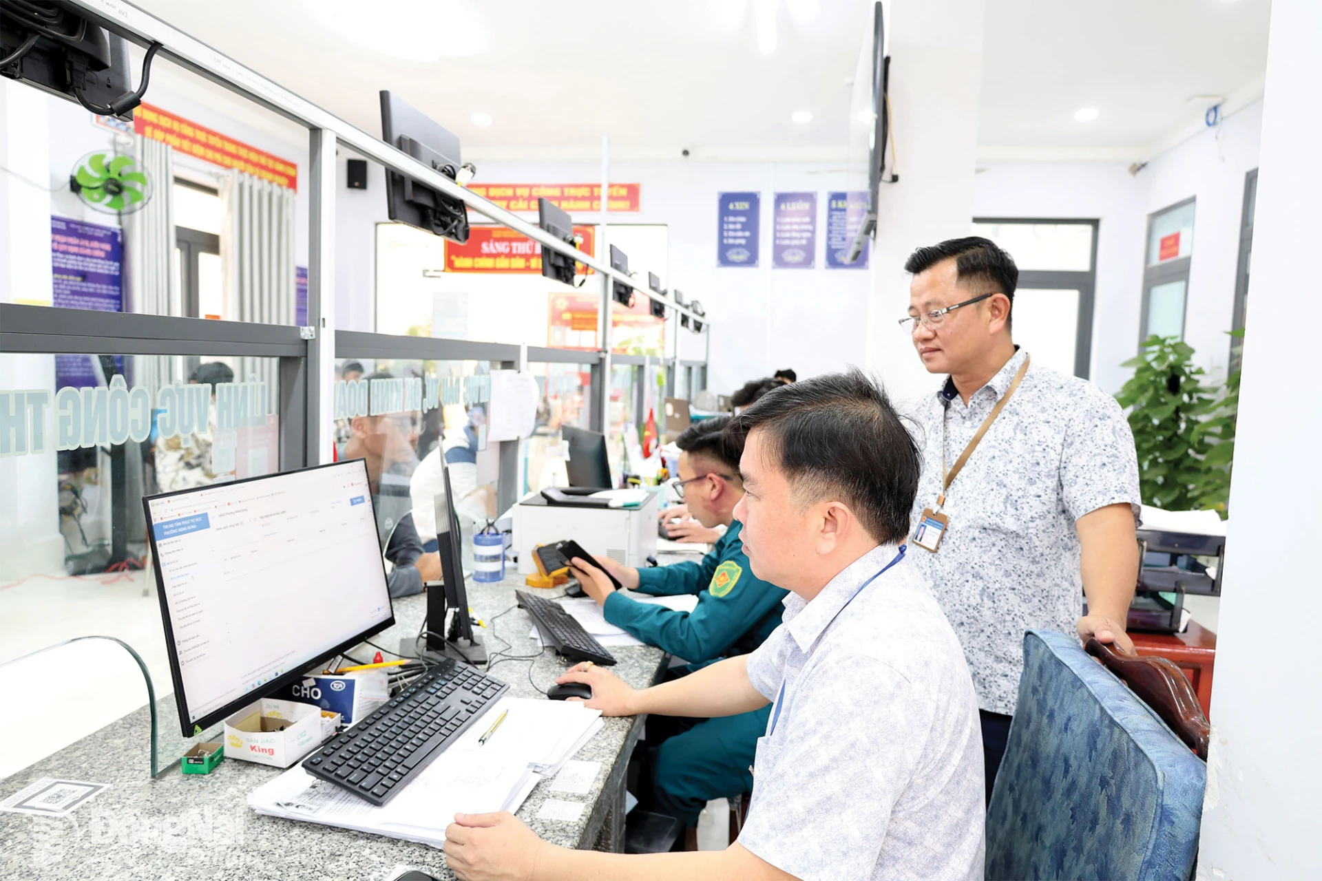 Cán bộ, công chức phường Minh Hưng trao đổi, xử lý công việc.