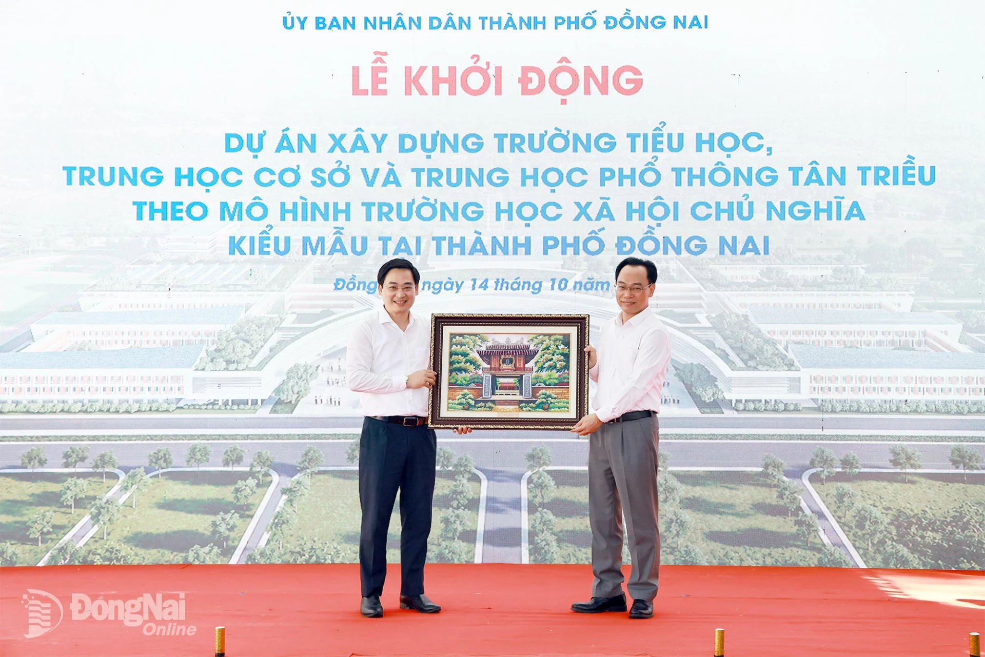Giám đốc Sở Giáo dục và Đào tạo Đặng Anh Tuấn nhận bức tranh Văn miếu Quốc Tử Giám từ Bộ trưởng Bộ Giáo dục và Đào tạo Hoàng Minh Sơn tặng nhà trường. Ảnh: Công Nghĩa