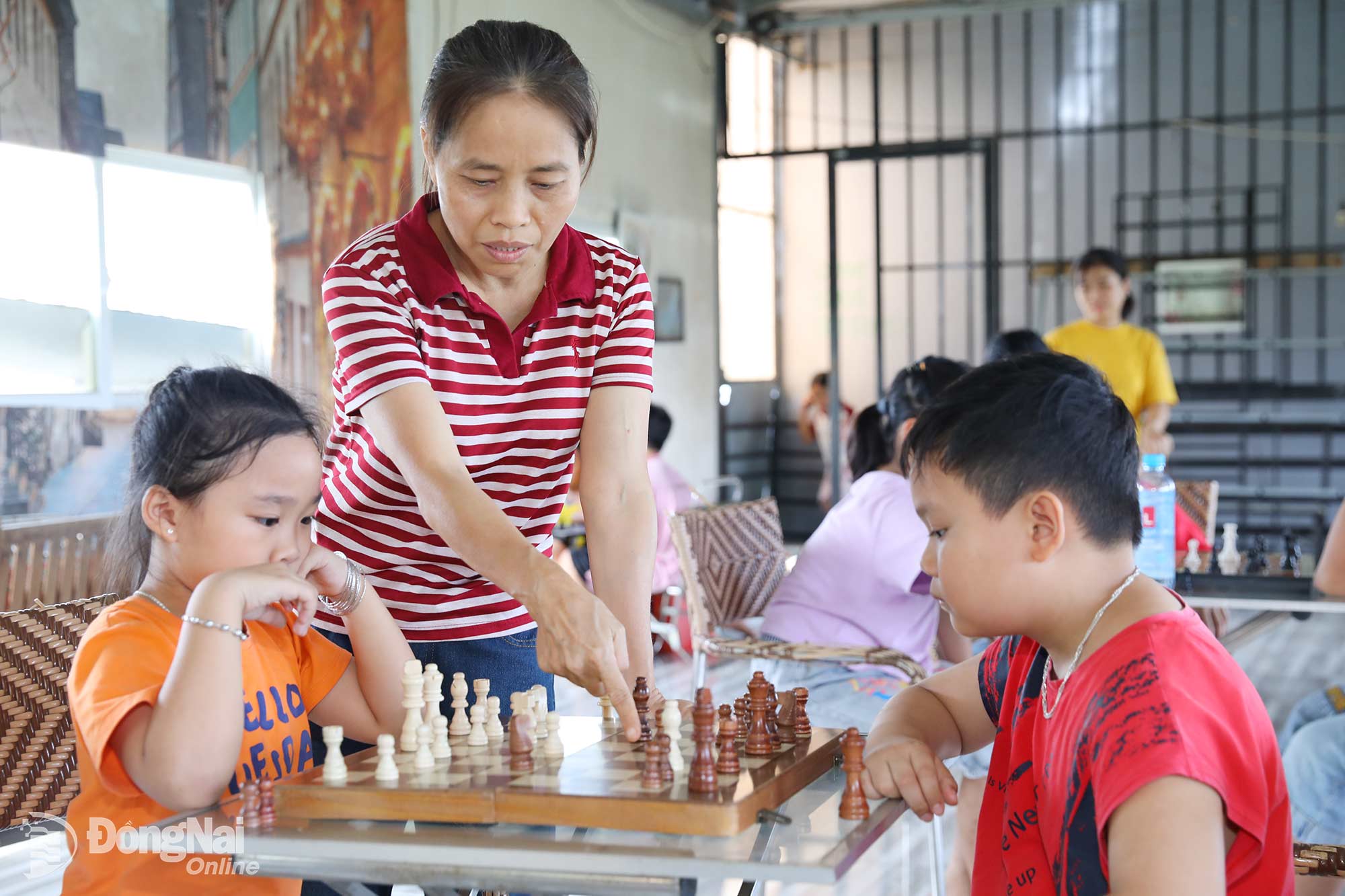 Cô Lê Thị Hợi hướng dẫn các em làm quen với cờ vua, cờ tướng. Ảnh: Huy Anh