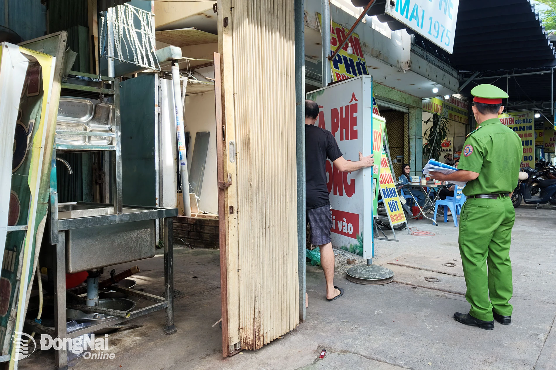 Lực lượng chức năng nhắc nhở các hộ kinh doanh thu dọn hàng hóa, vật dụng lấn chiếm lòng đường, vỉa hè. Ảnh: Lê Duy