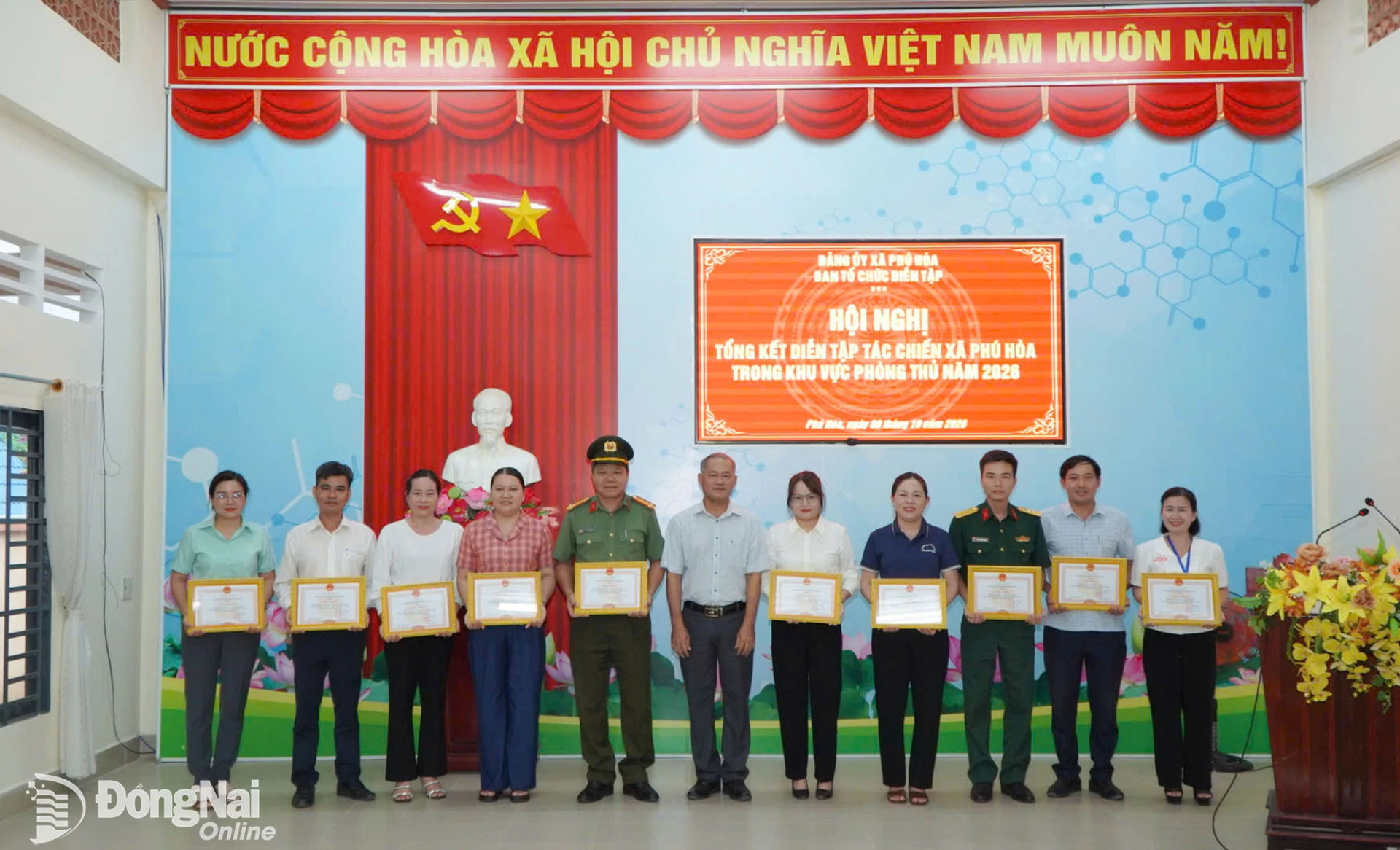 Đồng chí Trần Nam Biên, Bí thư Đảng ủy, Chủ tịch HĐND xã Phú Hòa trao tặng giấy khen cho các đơn vị xuất sắc trong công tác diễn tập tác chiến xã Phú Hòa năm 2026. Ảnh: Lê Trung

