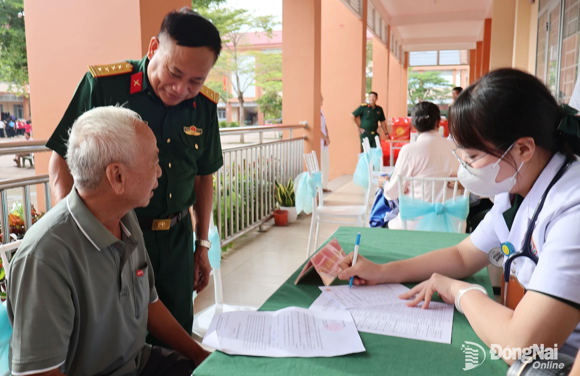 Colonel Nguyen Nhu Truc, Deputy Chief of Political Affairs of Military Region 7, encourages a person with meritorious service as he receives a medical checkup. Photo: Nguyet Ha.


