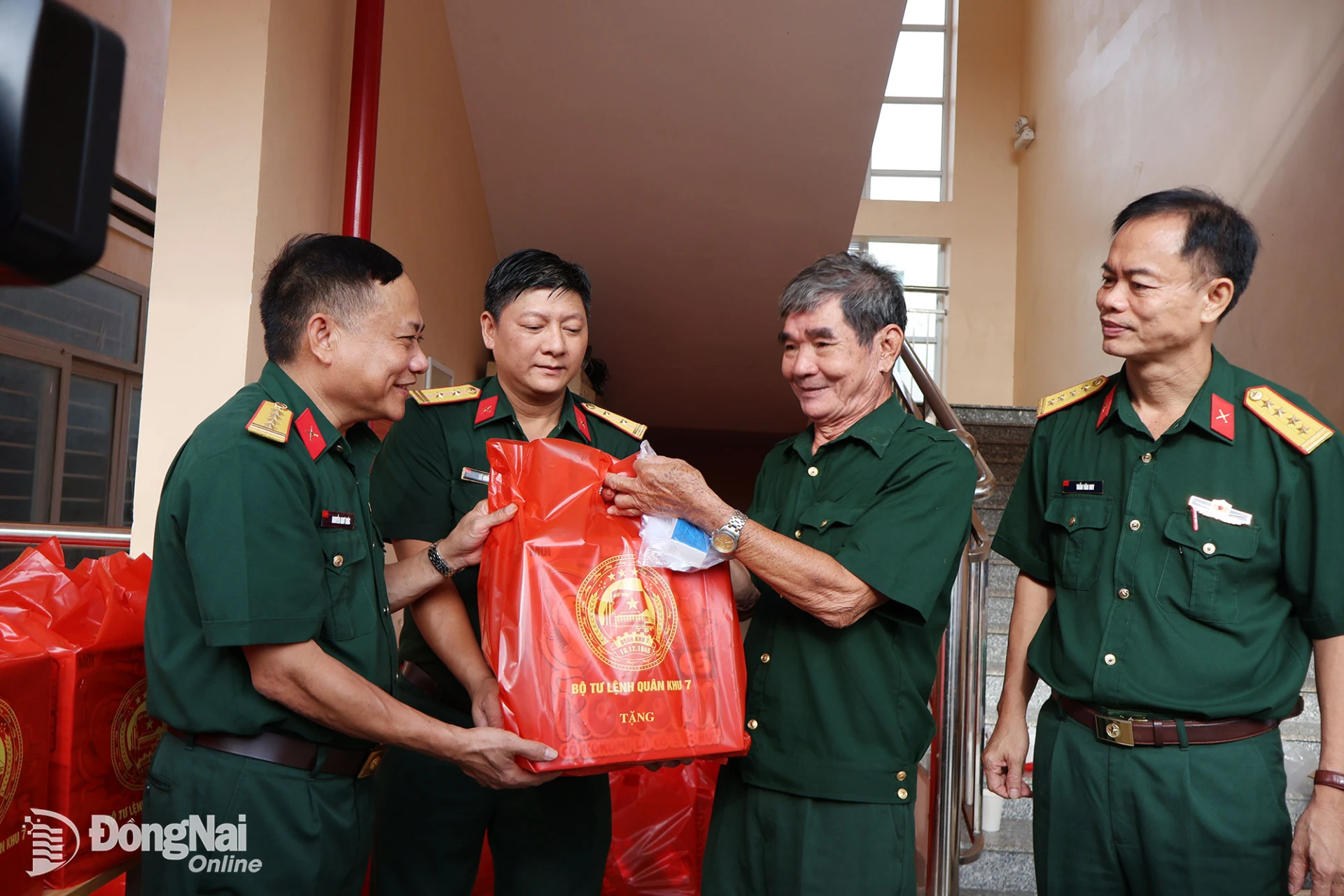 Colonel Nguyen Nhu Truc, Deputy Chief of Political Affairs of Military Region 7 (far left), presents a gift to a person with meritorious service during the free medical checkup program on October 3. Photo: Nguyet Ha.

