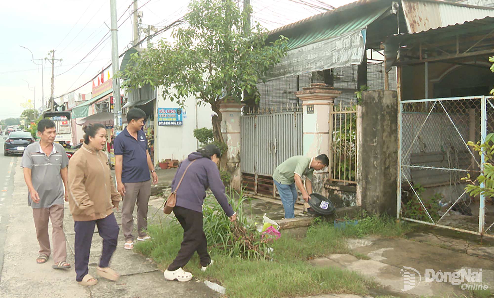 Ban điều hành khu phố Suối Đôi và các lực lượng tham gia kiểm tra, xử lý các điểm có nguy cơ phát sinh lăng quăng. Ảnh: Đỗ Trình