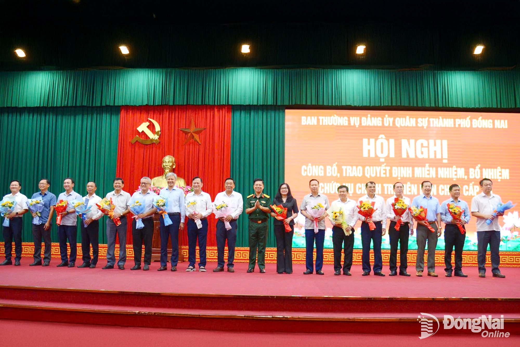 Đại tá Nguyễn Thanh Phong tặng hoa cảm ơn các đồng chí Bí thư Đảng ủy cấp xã đã từng giữ cương vị Chính trị viên Ban Chỉ huy Quân sự cấp xã thời gian qua. Ảnh: Phạm Khoa