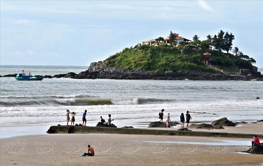 Tourists on Back Beach, with Hon Ba Island in the distance. 