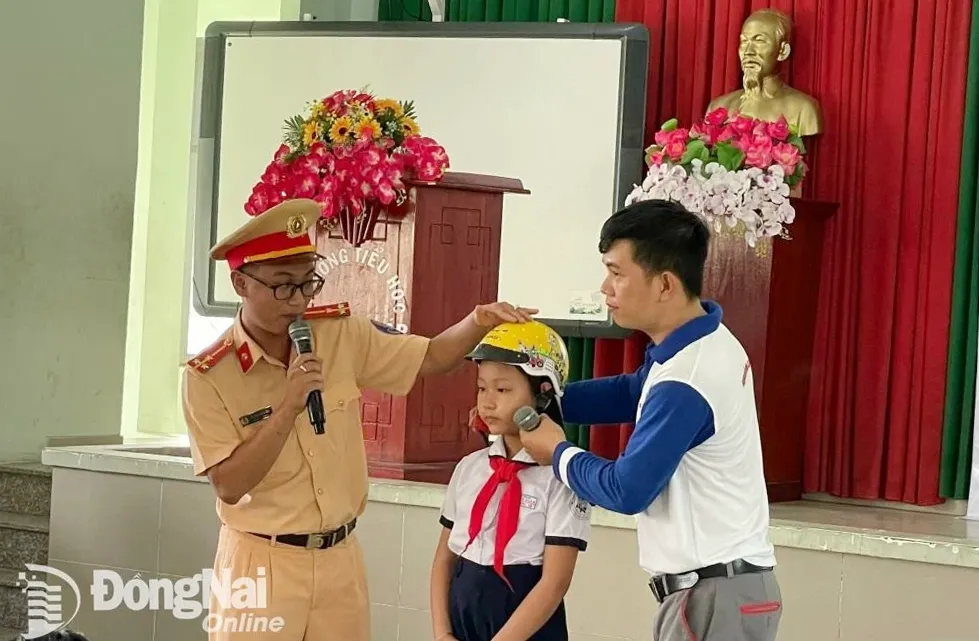 Học sinh Trường tiểu học Hà Huy Giáp được hướng dẫn đội mũ bảo hiểm đúng cách (Ảnh: Hội đồng Đội TP.Biên Hòa cung cấp)