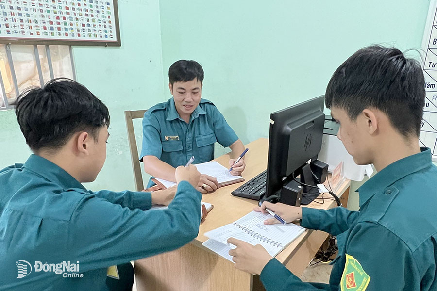 Ông Phạm Văn Tuấn (giữa) trao đổi với đồng đội kế hoạch tuần tra sau 21 giờ. Ảnh: N.Hà 