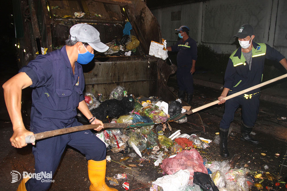 2.  Công nhân gom rác đêm ở ven đường