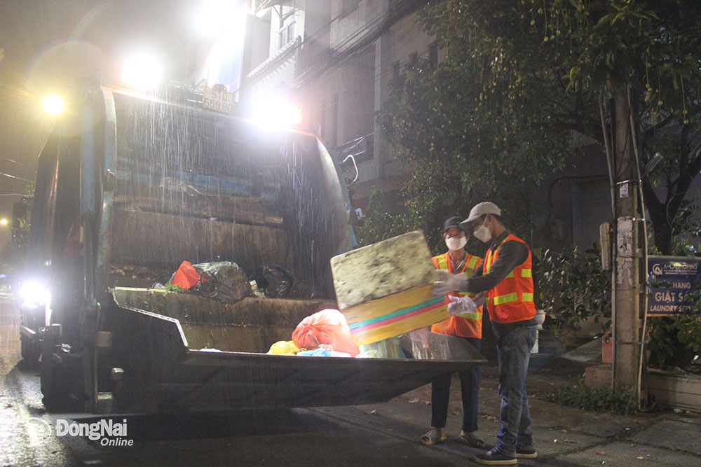 7.  Công nhân thu gom rác miệt mài với công việc khi gặp những cơn mưa đêm