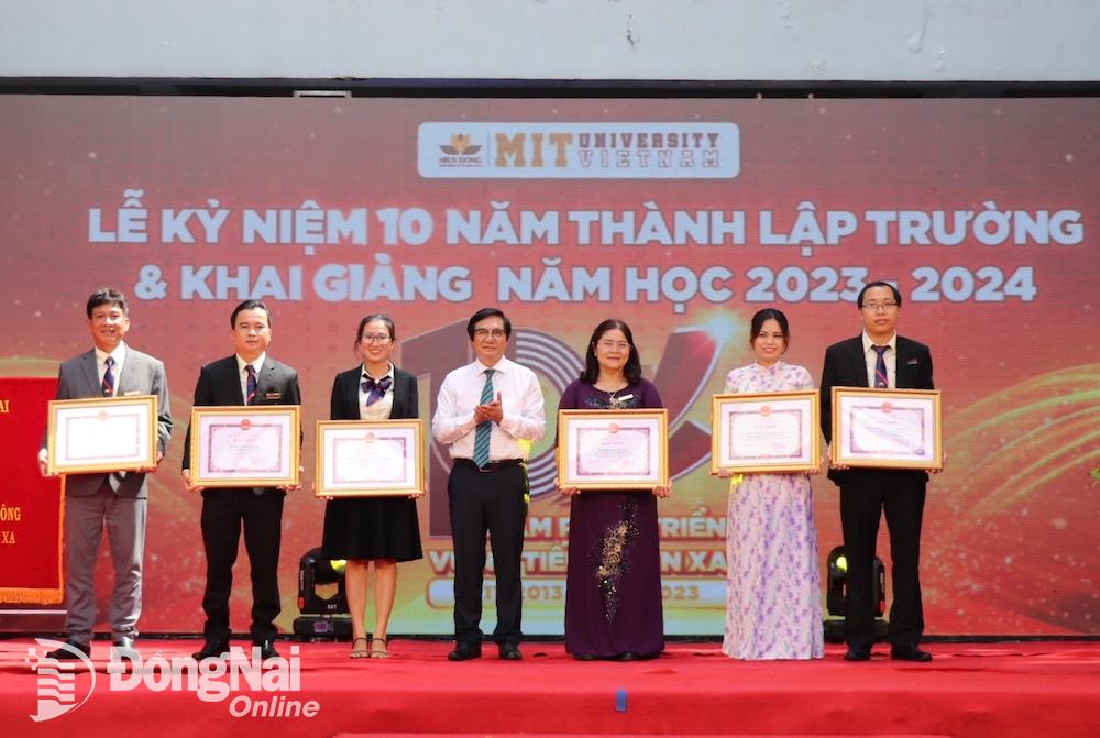 Phó chủ tịch UBND tỉnh Nguyễn Sơn Hùng trao bằng khen của UBND tỉnh cho các cá nhân có nhiều đóng góp cho quá trình phát triển của Trường đại học Công nghệ Miền Đông