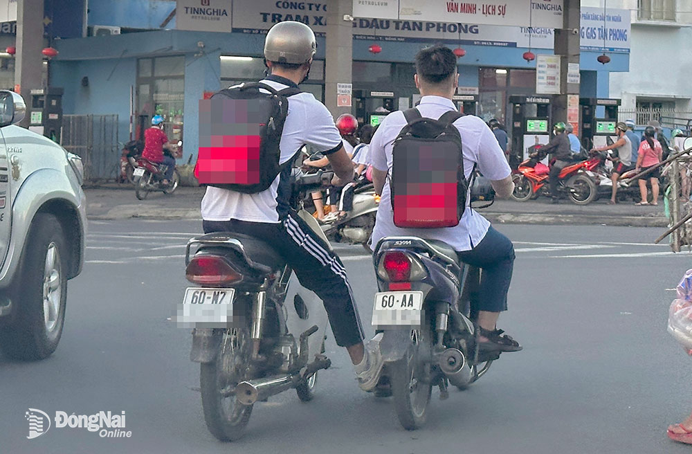 Một học sinh điều khiển xe kè một học sinh khác đi trên đường Nguyễn Ái Quốc, gần vòng xoay ngã tư Tân Phong (TP.Biên Hòa). Ảnh: Minh Thành