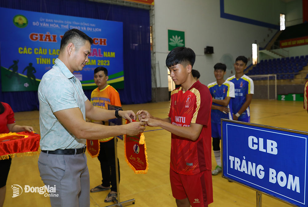 Phó giám đốc Trung tâm Huấn luyện và thi đấu TDTT tỉnh Huỳnh Trúc Phương tặng cờ lưu niệm cho các đội bóng tham dự lễ khai mạc