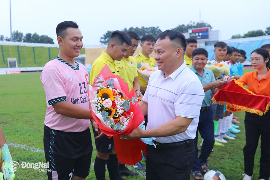 Giám đốc Trung tâm Huấn luyện và thi đấu TDTT tỉnh Bùi Anh Vũ tặng hoa cho hai đội bóng thi đấu trận khai mạc