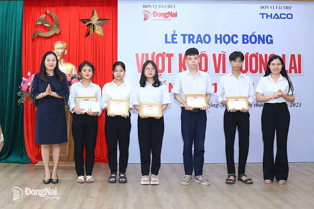 Phó tổng biên tập Báo Đồng Nai Hoàng Thị Bích Phú (bìa phải) và nhà báo Mai Thị Minh Thảo (áo đen) trao học bổng cho các em học sinh