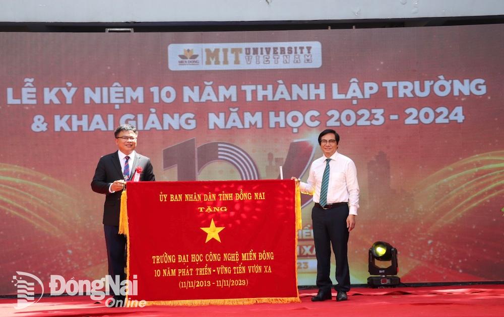 Phó chủ tịch UBND tỉnh Nguyễn Sơn Hùng trao tặng bức trướng của UBND tỉnh cho đại diện Ban giám hiệu Trường đại học Công nghệ Miền Đông