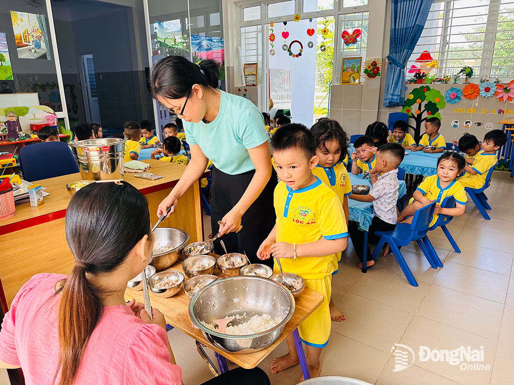Các học sinh Trường mầm non Lộc An xếp hàng nhận bữa ăn trưa tại trường