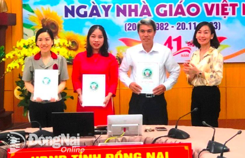 Giám đốc Sở GD-ĐT Trương Thị Kim Huệ trao quyết định cho ông Hồ Đức Nghỉ, Hồ Mai lan và Nguyễn Thị Trúc Tự