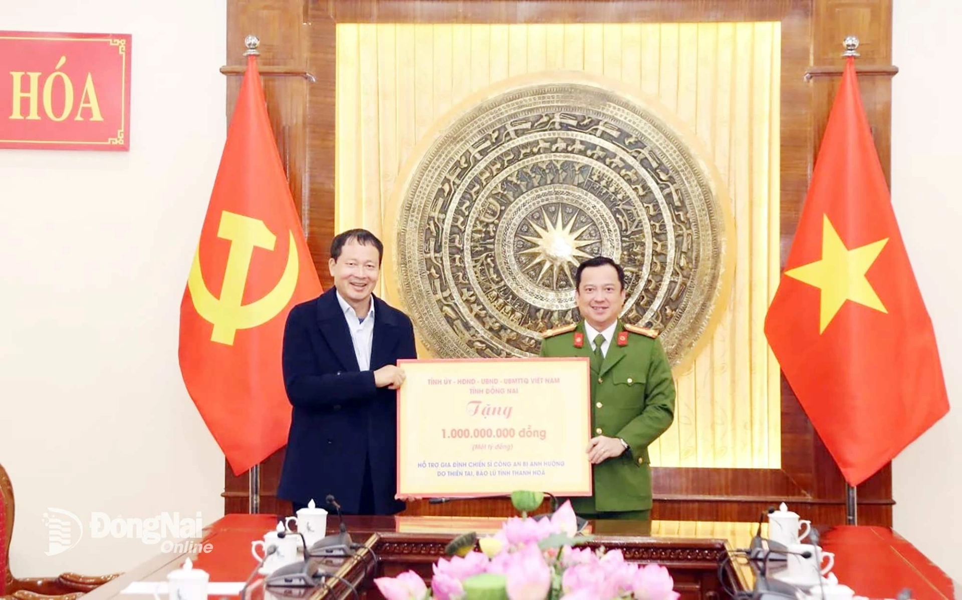 Secretary of the Dong Nai Provincial Party Committee, Head of the Provincial Delegation of National Assembly Deputies Vu Hong Van presents a symbolic check for the amount of money to support the families of police officers affected by natural disasters and floods. Photo: Phong Sac