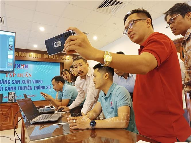 Phóng viên TTXVN trao đổi về cách dựng video bằng điện thoại di động tại lớp “Kỹ năng sản xuất video trong bối cảnh truyền thông số” được tổ chức ở Đà Nẵng. Ảnh: TTXVN