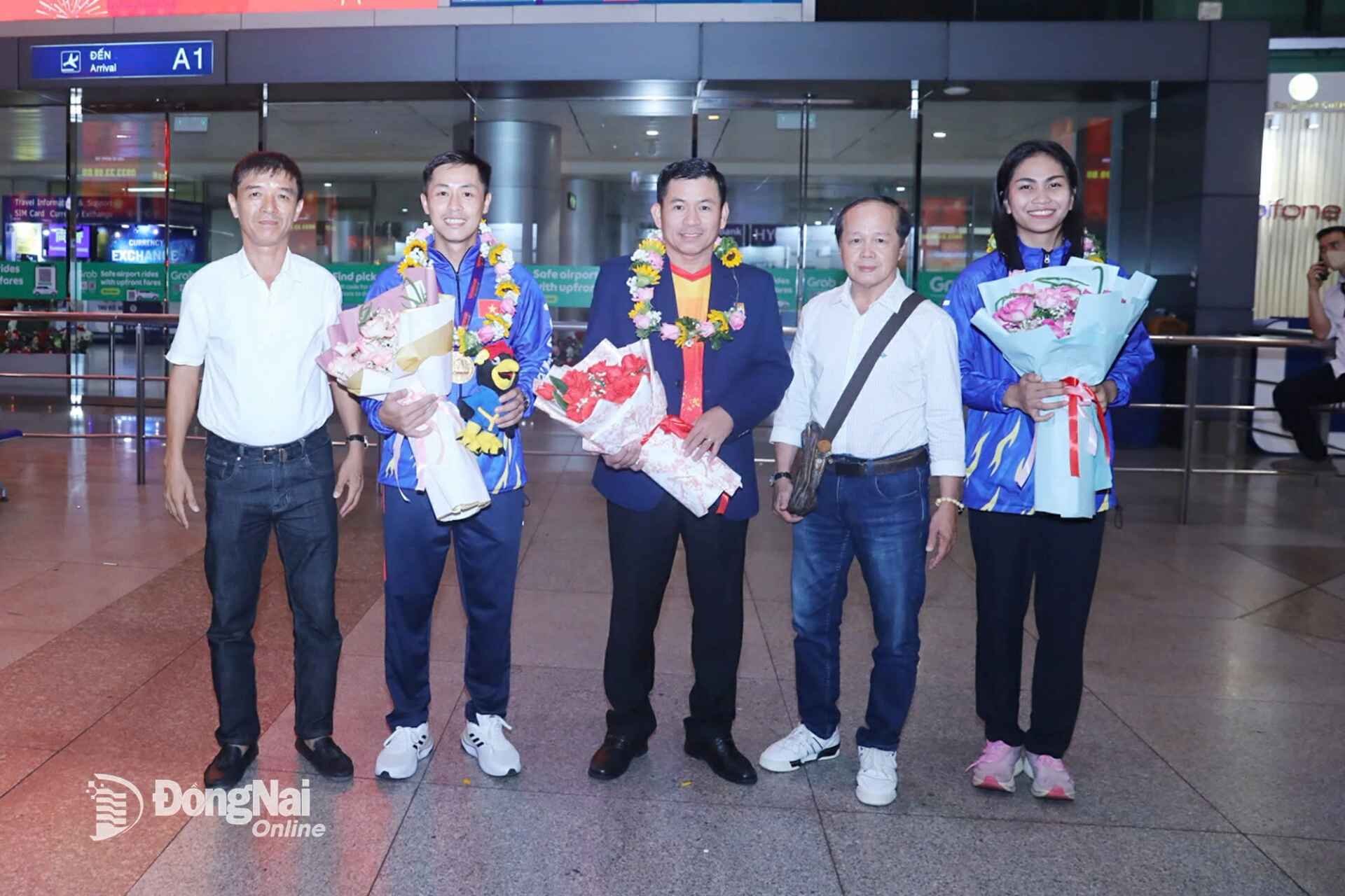 Vu Tien Phat, Head of the High-Performance Sports Training Department at the Dong Nai Provincial Sports Training and Competition Center, together with Deputy President of the Dong Nai Vovinam Federation and head coach Dinh Thien Tung, congratulates coach Huynh Minh Hai and his athletes at Tan Son Nhat Airport. Photo: Huy Anh	