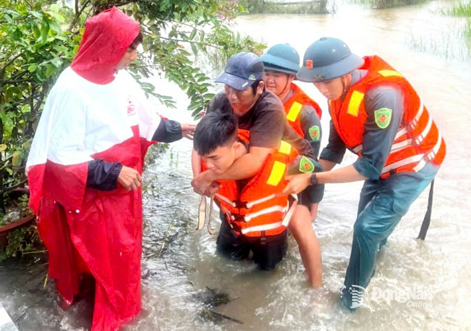 Lực lượng vũ trang tỉnh đưa 2 mẹ con bà Hồ Thị Bạch Tuyết bị tai biến ra khỏi dòng nước lũ. Ảnh: ĐVCC