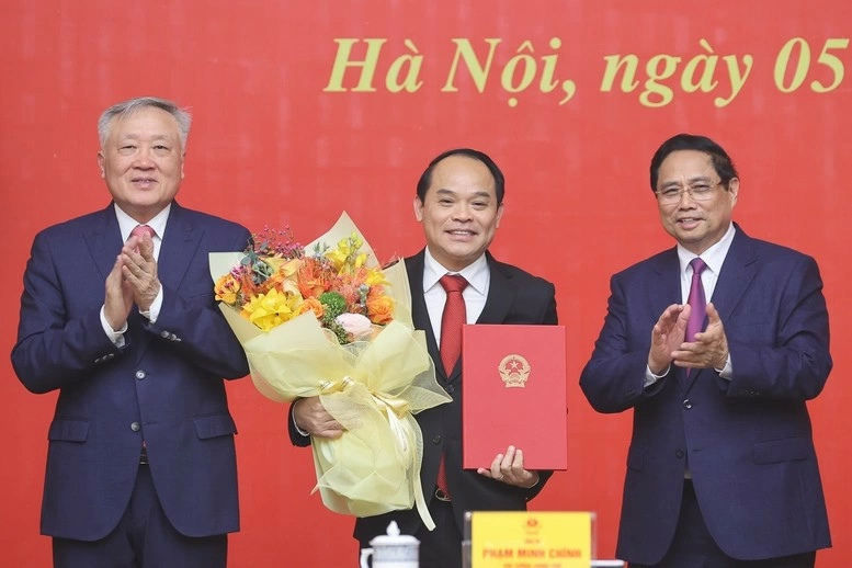 Prime Minister Pham Minh Chinh (right) and Permanent Deputy Prime Minister Nguyen Hoa Binh (left) present a decision appointing Nguyen Quoc Doan as Standing Deputy Inspector General of the Government Inspectorate. (Photo: VGP)