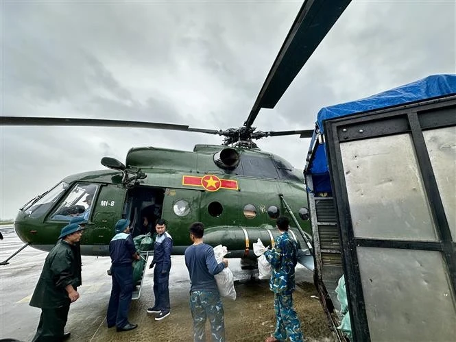 Relief supplies are loaded onto a helicopter for delivery to residents who remain isolated by floodwaters in the south-central provinces. (Photo: VNA)