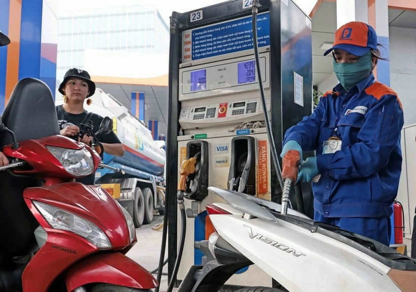 Khách hàng mua bán xăng, dầu tại một điểm kinh doanh xăng dầu của Petrolimex trên địa bàn Hà Nội. Ảnh: Trần Việt /TTXVN