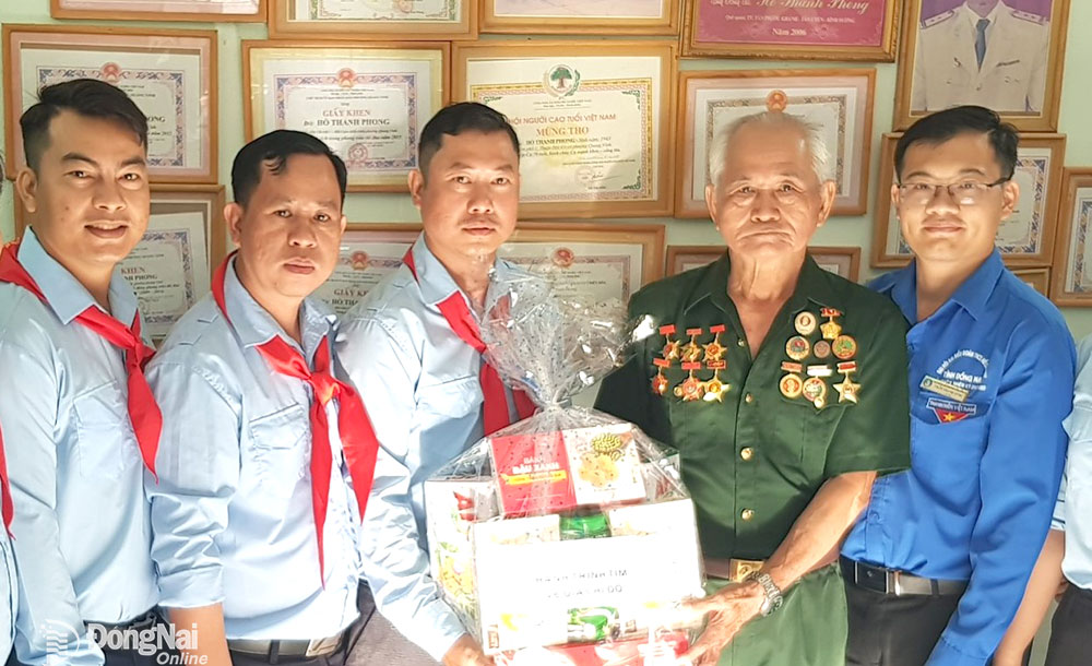 Thầy Phạm Vũ Bình (thứ 2 từ trái qua) tham gia tặng quà cho gia đình có công với cách mạng. Ảnh: NVCC