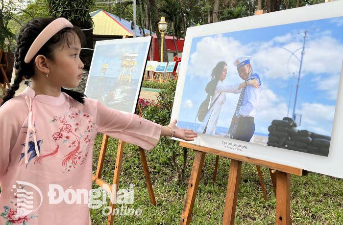 Bé Minh phải xem cho hết những bức hình triển lãm về biển đảo Tổ quốc của Báo Đồng Nai