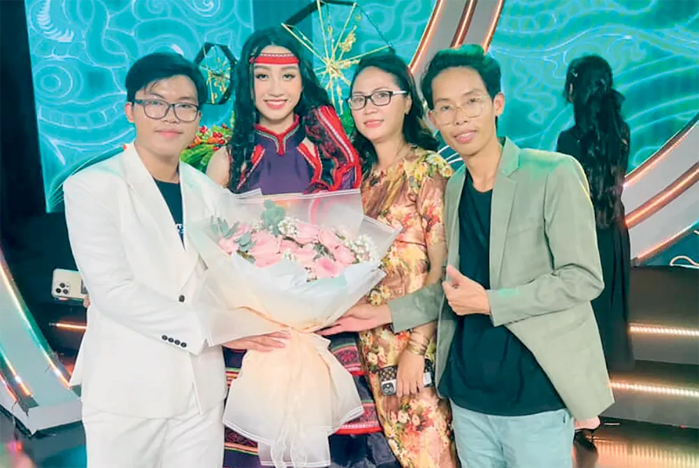 Trần Lê Đức Việt (bìa trái) chụp hình lưu niệm cùng thí sinh mặc bộ trang phục do em thiết kế . Ảnh: NVCC